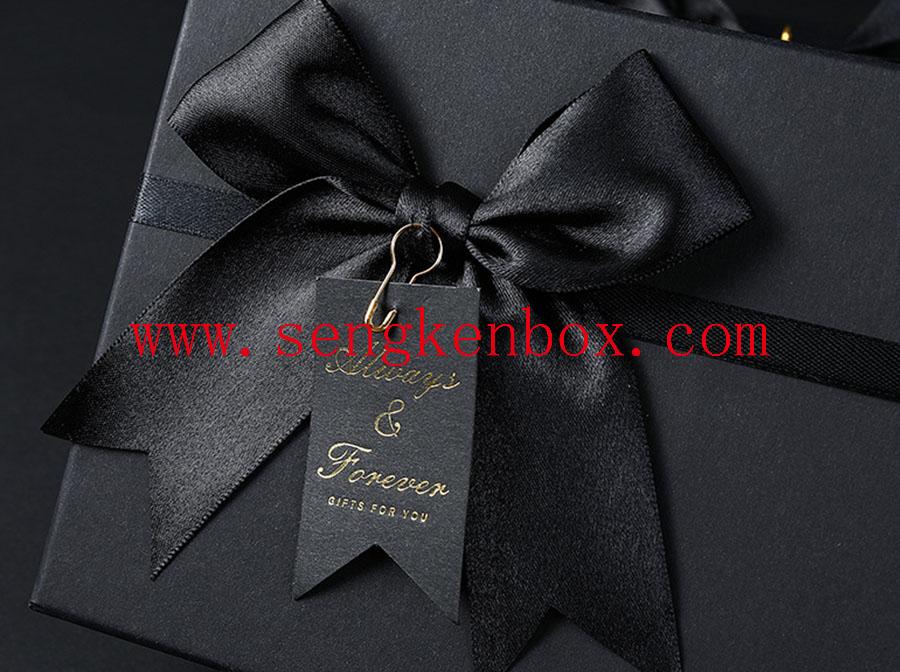 Schwarze Geschenkpapierbox mit Schleife